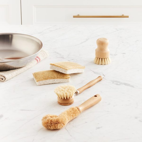 Bamboo dish brush set with three brushes and two cleaning pads on a countertop