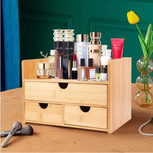 Three-drawer bamboo makeup organizer holding cosmetics on the open top shelf