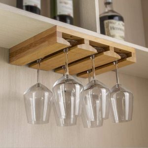 Under cabinet wine glass rack with three parallel channels holding stemware beneath a shelf