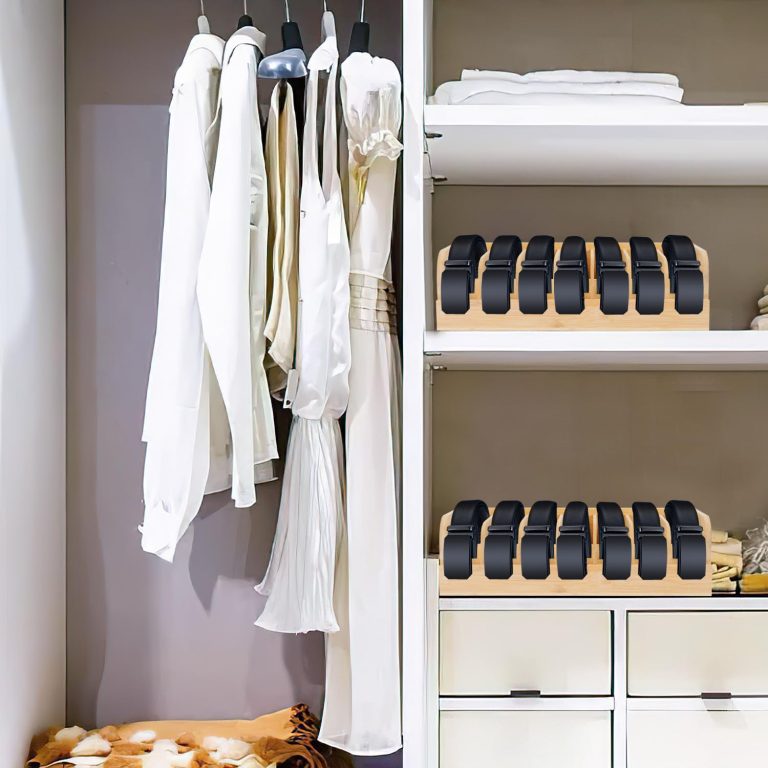 Two bamboo belt organizers holding rolled black belts on separate shelves beside hanging clothes