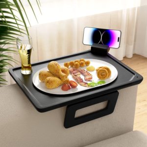 Bamboo couch arm tray in black holding a plate, drink and phone over a sofa arm