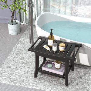 Black bamboo shower stool holding toiletries beside a bathtub with a tray on its lower shelf