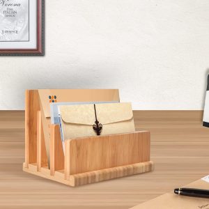 Bamboo letter organizer with three staggered slots holding envelopes and papers on a desk