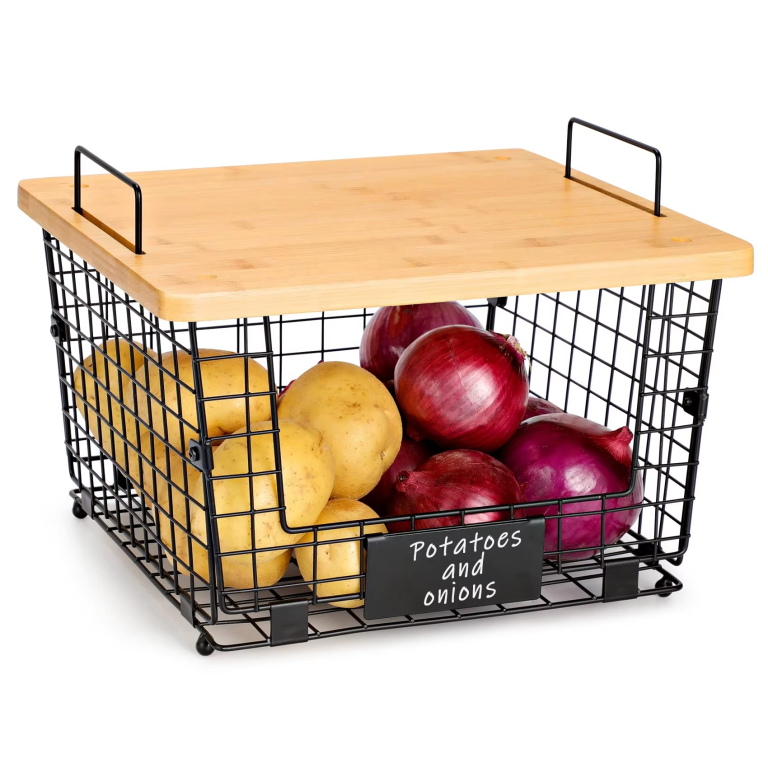 Black wire countertop organizer with a bamboo top, two loop handles and a front label panel, pictured with potatoes and onions on a white background
