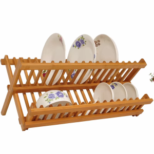 Folding dish drying rack with two angled slatted levels and crossed legs, pictured holding floral plates and bowls on a white background