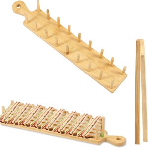 Bamboo taco stand with two rows of upright pegs, a handle hole and separate tongs, with sandwiches pictured below