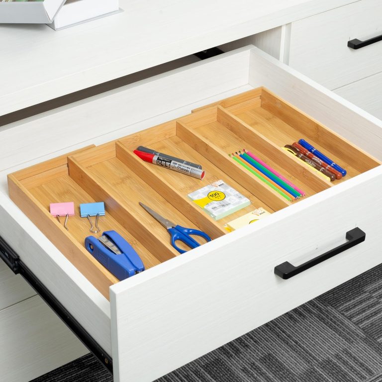 Bamboo drawer organizer holding pens, colored pencils, scissors, a stapler and binder clips in long compartments