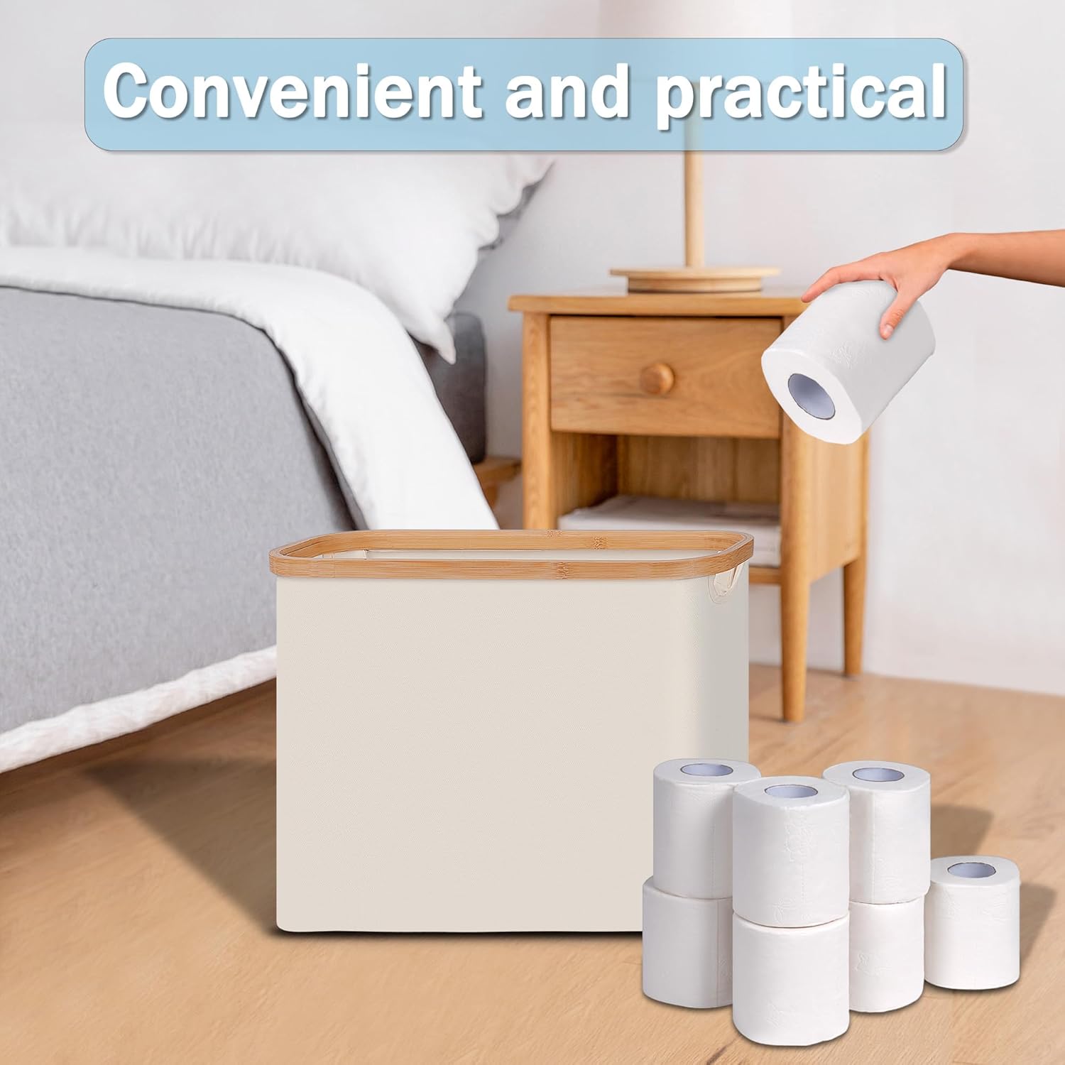 Open cream toilet paper basket beside a bed with a hand holding a roll above it and spare rolls arranged nearby