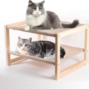 Wooden pet bunk beds with two cats resting on beige fabric hammocks in a light wood frame