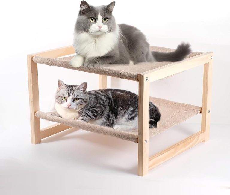 Wooden pet bunk beds with two cats resting on beige fabric hammocks in a light wood frame