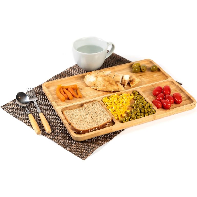 Bamboo divided serving tray with one long compartment and three smaller sections holding chicken, vegetables, bread and tomatoes