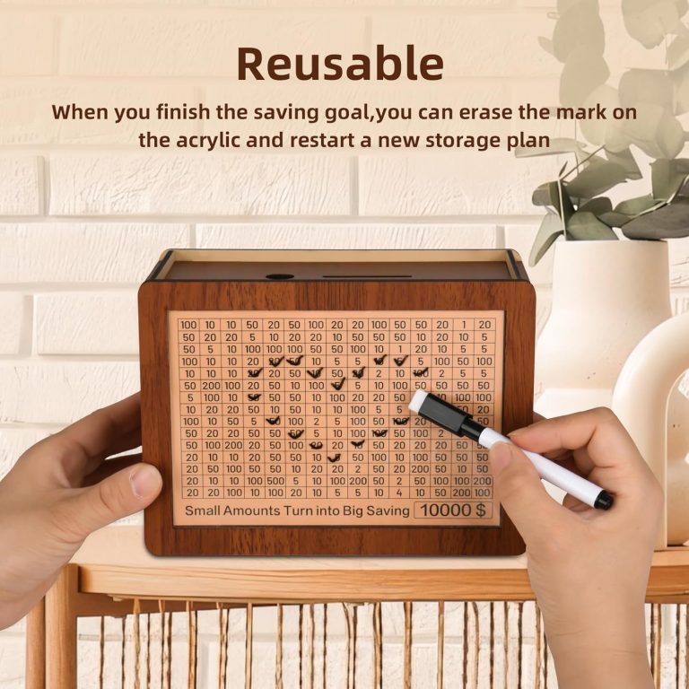 Hands holding a wooden savings challenge box while a marker is used on the clear front over the numbered goal grid