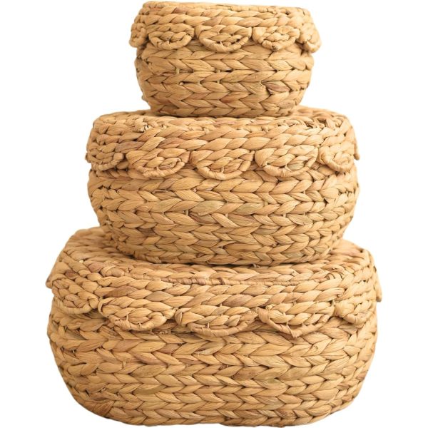 Water hyacinth storage basket set of three oval baskets stacked with scalloped lids on a white background