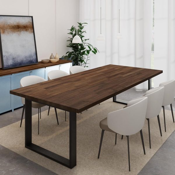 Rectangular dark walnut colored acacia table top on black metal legs in a dining room with upholstered chairs