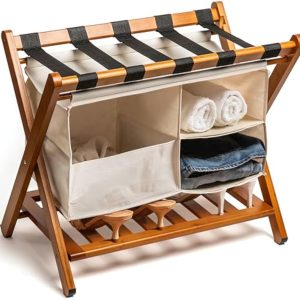 Bamboo luggage rack with black top straps, a hanging fabric organizer and a lower slatted shelf, pictured with towels, clothing and shoes