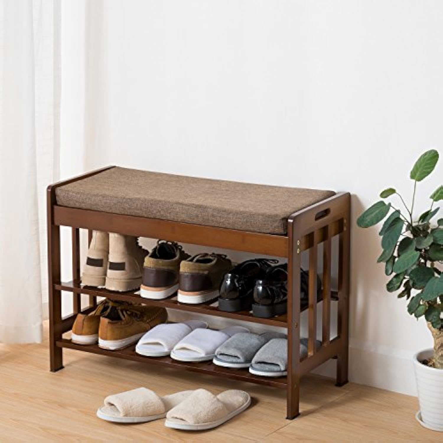 Brown bamboo shoe rack bench with a fabric cushion and shoes arranged on two slatted shelves