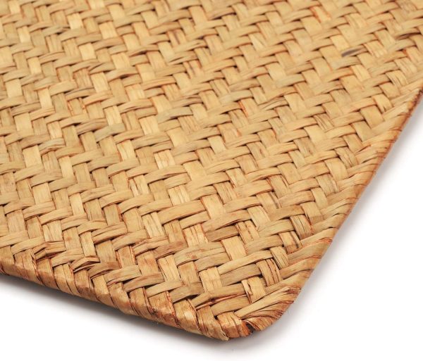 Close-up of a seagrass placemat showing the woven pattern, bound edge and rounded corner