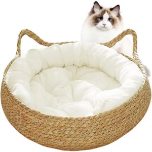 Round straw woven cat bed with a white bolster and base cushion, with a cat behind the basket