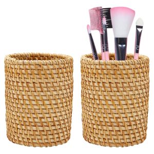 Two cylindrical rattan pencil holders, one empty and one displaying makeup brushes and a comb