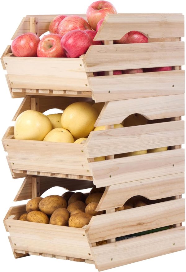 Three wooden produce bins stacked with open fronts and filled with apples, lemons and potatoes against a white background