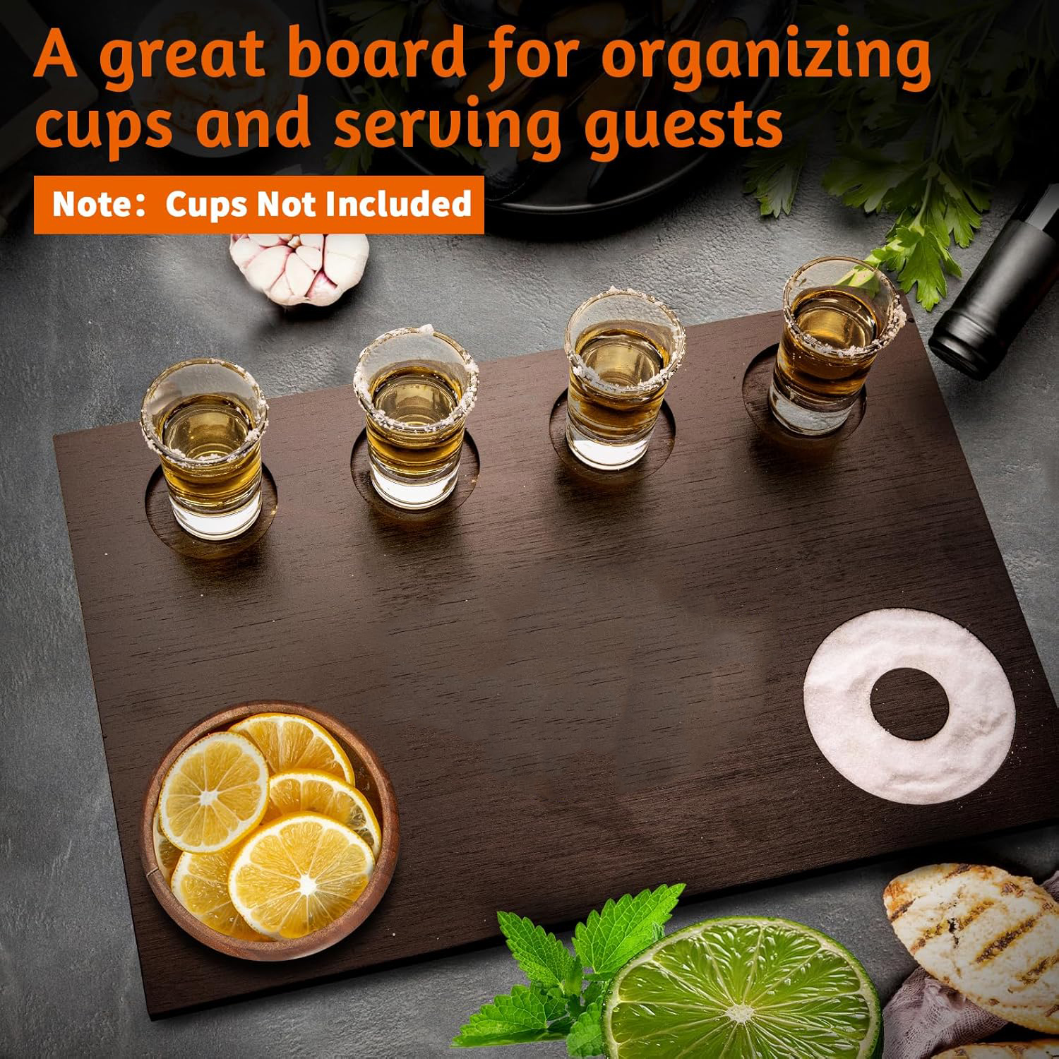 Four shot glasses displayed on a rectangular dark wooden board with citrus and salt, beside a cups-not-included label