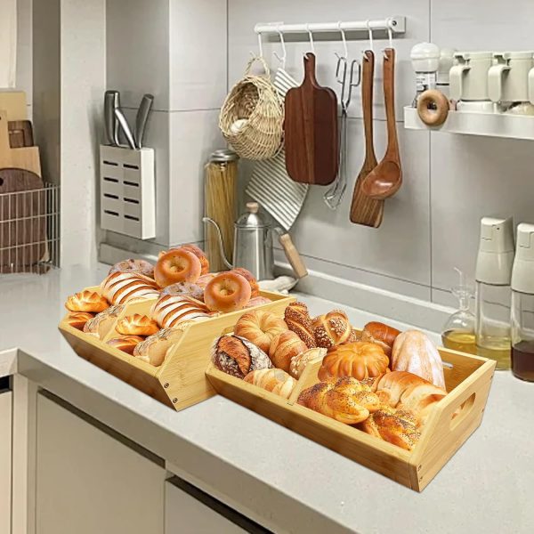 Two bamboo storage baskets placed side by side on a kitchen counter with bread and pastries